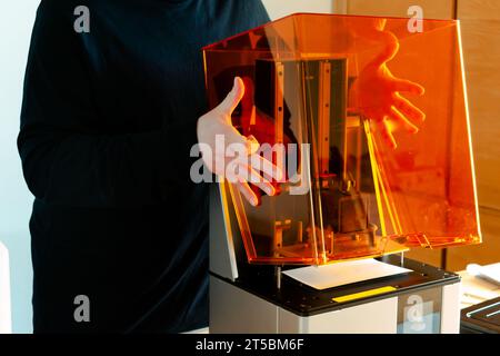 Mann, der einen 3D-Harzdrucker vor der Verwendung vorbereitet Stockfoto