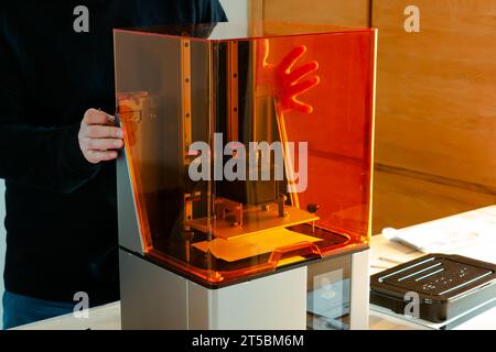 Mann, der einen 3D-Harzdrucker vor der Verwendung vorbereitet Stockfoto