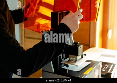 Mann, der einen 3D-Harzdrucker vor der Verwendung vorbereitet Stockfoto