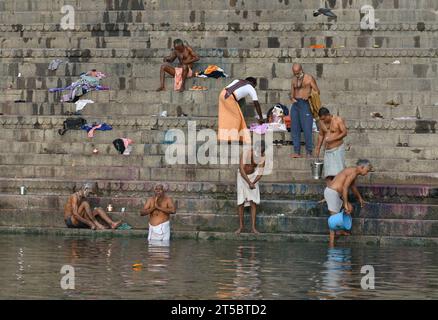 VARANASI, INDIEN - 13. November 2022: Blick von einem Boot aus gleitet durch das Wasser auf dem Ganges Fluss entlang der Küste von Varanasi. Stockfoto