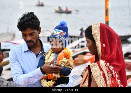 VARANASI, INDIEN - 13. November 2022: Porträt einer jungen indischen Familie mit Kind in den Straßen von Varanasi. Stockfoto