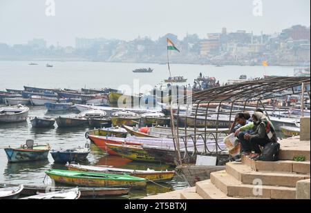 VARANASI, INDIEN - 13. November 2022: Blick von einem Boot aus gleitet durch das Wasser auf dem Ganges Fluss entlang der Küste von Varanasi. Stockfoto