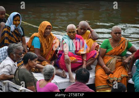 VARANASI, INDIEN - 13. November 2022: Frau sitzt nachts in der Nähe eines zeremoniellen Feuers in der Nähe des Heiligen Ganges. Manikarnika Ghat Stockfoto