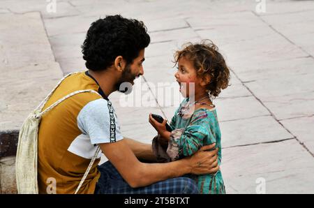 VARANASI, INDIEN - 13. November 2022: Porträt eines kleinen indischen Mädchens mit Vater macht Spaß in den Straßen von Varanasi. Stockfoto