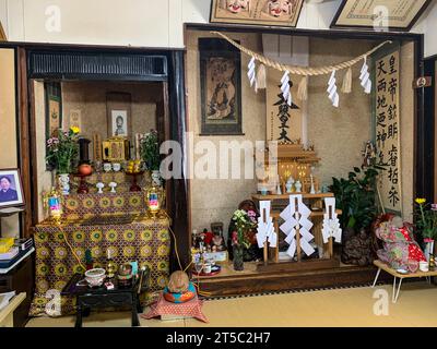 Japan, Kyushu. Familienaltar zu Ehren der Vorfahren auf der linken Seite, Shinto-Schrein auf der rechten Seite. Stockfoto