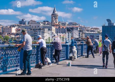 Istanbul, Türkei, Türkiye. Fischer auf der Galata-Brücke. Galataturm im Hintergrund. Stockfoto