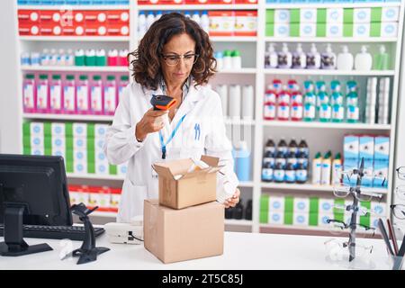Frau mittleren Alters Apotheker Scannen Pillen Flasche in der Apotheke Stockfoto