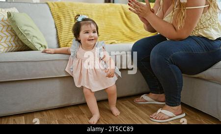 Mutter und Tochter genießen lustiges Klatschspiel auf dem Sofa und feiern mit Applaus in liebevoller Atmosphäre Stockfoto