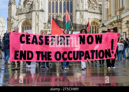 Bath, UK. November 2023. Pro-palästinensische Anhänger, die Plakate tragen und palästinensische Fahnen schwenken, sind vor der Abtei Bath abgebildet, während sie in einem protestmarsch durch Bath marschieren, um ihre Solidarität mit dem palästinensischen Volk zu zeigen. Der protestmarsch „Waffenruhe jetzt“ und die Kundgebung wurden abgehalten, um es den Menschen zu ermöglichen, ihre Unterstützung und Solidarität mit dem palästinensischen Volk zu zeigen und gegen Israels jüngste Aktionen im Gaza-Streifen zu protestieren. Quelle: Lynchpics/Alamy Live News Stockfoto