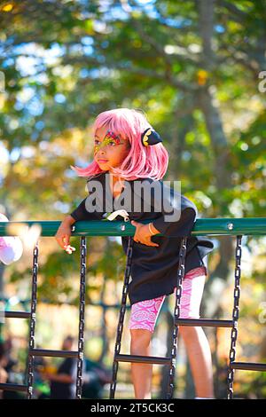 Halloweenpalooza - Dennis, Massachusetts auf Cape Cod. Eine Familienfeier an Halloween. Ein Mädchen mit magentafarbenen Haaren im Dschungelstudio Stockfoto