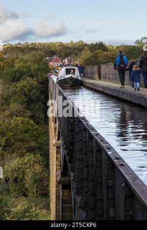 Kanalboot, das auf dem Pontcysyllte Aquädukt fährt, während die Menschen den Opersite Way laufen, aufgenommen am 21. Oktober 2023. Stockfoto