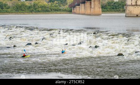 Granite City, Il, USA - 8. Oktober 2023: Zwei Wildwasserkayaker spielen und trainieren unter dem Low Water Dam am am Mississippi River bei Chain of Rocks n Stockfoto