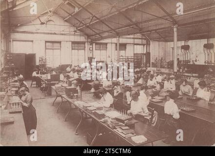 Arbeiterinnen aus Kriegszeiten saßen an Werkbänken und stellten in einem Arbeitszimmer einer Walthamstow-Fabrik Sicherungen für Munition zusammen. Das Foto, das rund um den Ersten Weltkrieg aufgenommen wurde, wurde im Welsh's Studio in Edmonton, North London, veröffentlicht Stockfoto