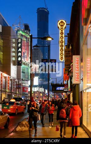 Toronto, Kanada, 2013, Menschen, die auf einem Bürgersteig in der Yonge Street im Stadtzentrum laufen. Ein Schild von Ed Mirvish und ein Sears Store sind beleuchtet A Stockfoto