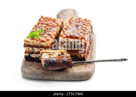 Schichtkuchen mit Karamellcreme und Nüssen isoliert auf weiß Stockfoto