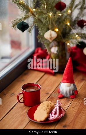 weihnachtszwerg, Kaffee und Kekse auf der Fensterbank Stockfoto