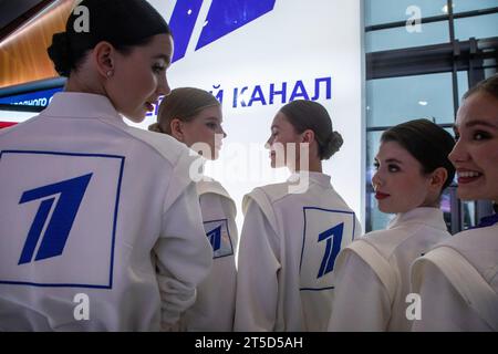 Moskau, Russland. November 2023. Mädchen in weißen Overalls mit dem Channel One Russia Logo auf dem Internationalen Ausstellungsforum „Russland“ im VDNH-Ausstellungskomplex in Moskau, Russland Stockfoto