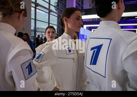 Moskau, Russland. November 2023. Mädchen in weißen Overalls mit dem Channel One Russia Logo auf dem Internationalen Ausstellungsforum „Russland“ im VDNH-Ausstellungskomplex in Moskau, Russland Stockfoto