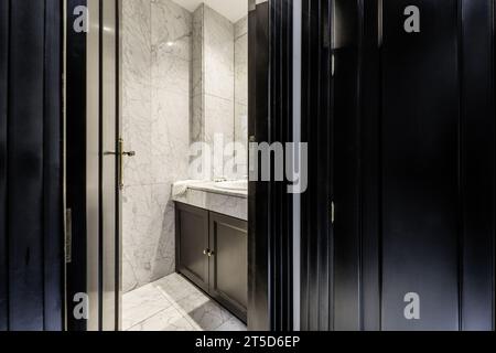 Kleines, modernes Badezimmer mit Marmorfliesen und Ablagefläche aus dem gleichen Material. Stockfoto
