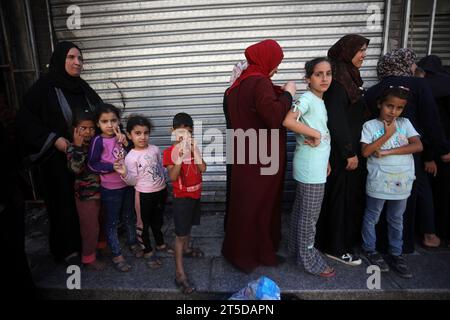 Al Nosirat, Gaza. November 2023. Palästinensische Frauen stehen am Samstag, dem 4. November 2023, an, um frisches Brot neben zerstörten Gebäuden im Flüchtlingslager Nuseirat im zentralen Gazastreifen zu kaufen. Nach Angaben des gesundheitsministeriums wurden 9.488 Menschen getötet, davon etwa zwei Drittel Frauen und Kinder. Foto: Ismael Mohamad/UPI Credit: UPI/Alamy Live News Stockfoto