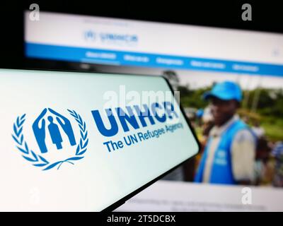 Smartphone mit Logo des Hohen Flüchtlingskommissars der Vereinten Nationen (UNHCR) vor der Website. Fokussieren Sie sich auf die linke Mitte des Telefondisplays. Stockfoto