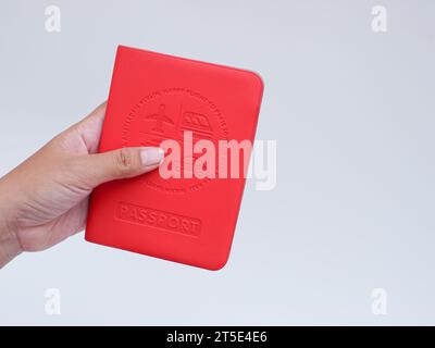 Hand haltendes Passbuch mit rotem Umschlag isoliert auf weiß Stockfoto