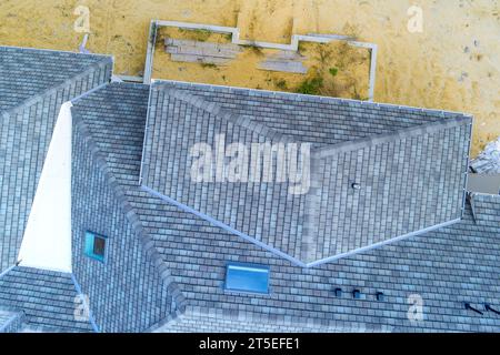 Beim Bau von neu gebauten Haus Dach wird mit Asphalt Schindeln als Haus gebaut Platz bedeckt Stockfoto