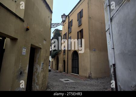 Ecke zwischen engen und kopfsteingepflasterten Gassen an bewölktem Tag in einer italienischen Stadt Stockfoto