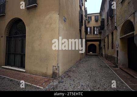 Ecke zwischen engen und kopfsteingepflasterten Gassen an bewölktem Tag in einer italienischen Stadt Stockfoto