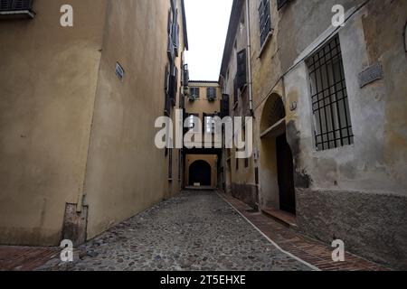 Ecke zwischen engen und kopfsteingepflasterten Gassen an bewölktem Tag in einer italienischen Stadt Stockfoto