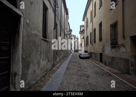 Kopfsteinpflaster und enge Gasse zwischen Gebäuden an einem bewölkten Tag in einer italienischen Stadt Stockfoto