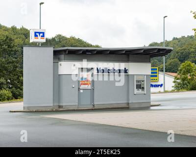 Geldautomat der Volksbank in einem kleinen Gebäude auf einem Parkplatz. Geldautomat einer deutschen Bank neben einem Supermarkt. Stockfoto