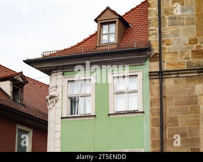 Schmales Gebäude neben einer Sandsteinmauer. Nahaufnahme des Hauses mit den Fenstern. Die Architektur ist alt und gehört zur historischen Stadt. Stockfoto