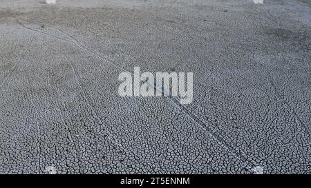 Aus der Vogelperspektive eines alten Bootes auf dem trockenen Limboto See. Aus der Vogelperspektive eines kaputten Holzbootes, das auf trockenem Land verlassen wurde. Globale Erwärmung Stockfoto