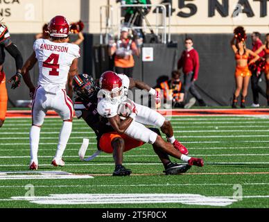 Stillwater, Oklahoma, USA. November 2023. Oklahoma Sooners Running Back Daylan Smothers (7) leitet den Ball, während er während des Spiels am Samstag, den 4. November 2023 im Boone Pickens Stadium in Stillwater, Oklahoma, von einem Oklahoma State Cowboy-Verteidiger in Angriff genommen wird. (Kreditbild: © Nicholas Rutledge/ZUMA Press Wire) NUR REDAKTIONELLE VERWENDUNG! Nicht für kommerzielle ZWECKE! Stockfoto