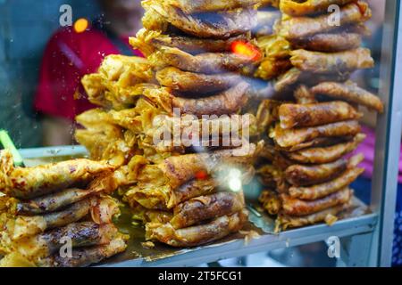 Gebratene Schokoladen-Bananenkuchen werden in einer Glas-Streetfood-Ausstellung angeordnet Stockfoto