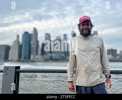 New York, USA. November 2023. Jonas Deichmann, Extremsportler aus Deutschland, steht vor der Skyline von New York. Deichmann radelte und rannte von New York nach Los Angeles und zurück. (Zu dpa-Korr: „Mental feat: German Extremsportler schließt US-Tour ab“) Credit: Benno Schwinghammer/dpa/Alamy Live News Stockfoto