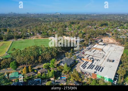 Panoramaaufnahme der Drohne eines Wohn- und Einkaufszentrums an den Northern Beaches, mit Stadt in der Ferne, Sydney, Australien. Stockfoto