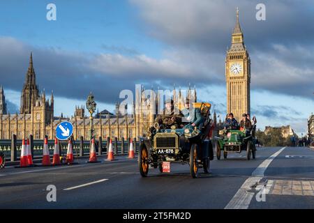 London, Großbritannien. 5. November 2023. Teilnehmer an Oldtimern überqueren die Westminster Bridge während des London-Brighton-Veteran-Car-Laufs. Mehr als 400 Oldtimer aus der Zeit vor 1905 nehmen am 127. Jahrestag des historischen Emancipation Run Teil, bei dem die Verabschiedung des Lokomotiven-on-Highway-Gesetzes gefeiert wurde, das die Geschwindigkeitsbegrenzung von 4 mph auf 14 mph erhöht. ohne die Notwendigkeit, Fahrzeugen einen Mann mit roter Warnfahne voraus zu geben, beendet damit Jahrhunderte des Pferdeverkehrs und gibt dem Autofahrer die Freiheit der Straße Stockfoto