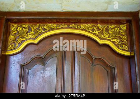 Eine Holzschnitzerei in Form einer goldenen Blume ist an der Tür des Hauses zu sehen Stockfoto