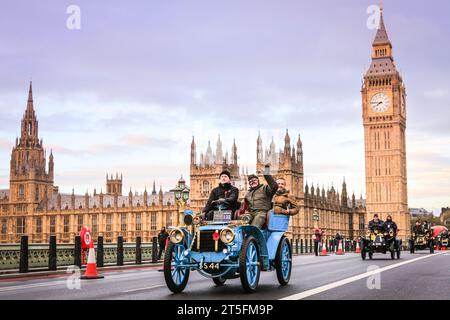 London, Großbritannien. November 2023. Ein Panhard et Levassor aus dem Jahr 1902 führt eine Gruppe von Veteranenautos auf der Westminster Bridge, Houses of Parliament im Hintergrund. Der RM Sotheby's London to Brighton Veteran Car Run, eines der am längsten laufenden Motorsportveranstaltungen weltweit, startet im Hyde Park, wo sie die Mall, Whitehall und Westminster Bridge besuchen, bevor sie ihre Reise an die Küste von Sussex fortsetzen. Ein teilnehmendes Fahrzeug muss vor 1905 an dem Rennen teilnehmen. Quelle: Imageplotter/Alamy Live News Stockfoto