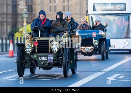 London, Großbritannien. 5. November 2023. Teilnehmer an Oldtimern überqueren die Westminster Bridge während des London-Brighton-Veteran-Car-Laufs. Mehr als 400 Oldtimer aus der Zeit vor 1905 nehmen am 127. Jahrestag des historischen Emancipation Run Teil, bei dem die Verabschiedung des Lokomotiven-on-Highway-Gesetzes gefeiert wurde, das die Geschwindigkeitsbegrenzung von 4 mph auf 14 mph erhöht. ohne die Notwendigkeit, Fahrzeugen einen Mann mit roter Warnfahne voraus zu geben, beendet damit Jahrhunderte des Pferdeverkehrs und gibt dem Autofahrer die Freiheit der Straße Stockfoto