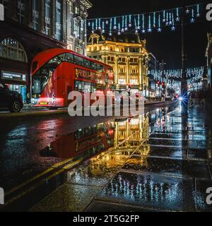 Reflexionen der Verkehrs- und weihnachtsbeleuchtung auf der Oxford Street in London. Stockfoto