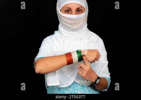 Eine junge Indianerin mit einem farbigen Finger zeigt Armreifen in den Farben der Trikolore mit Kreuzhand Stockfoto