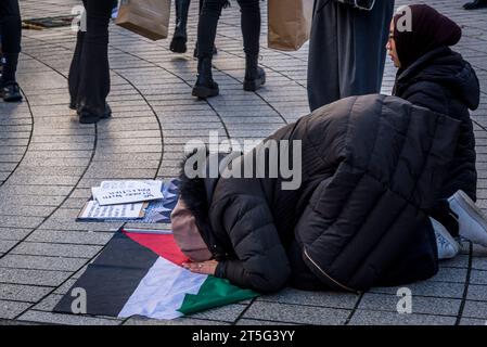 Muslimische Frau betet beim propalästinensischen Protest am 4. November 2023 auf dem Trafalgar Square, London, England, Großbritannien Stockfoto