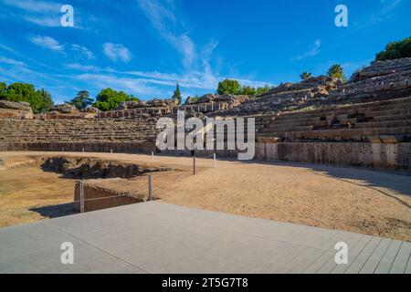 Blick vom hölzernen Fußweg auf die Arena des römischen Amphitheaters von Mérida, beleuchtet durch das Licht der Dämmerung, die Schatten auf seinen Ständen in Badaj erzeugt Stockfoto