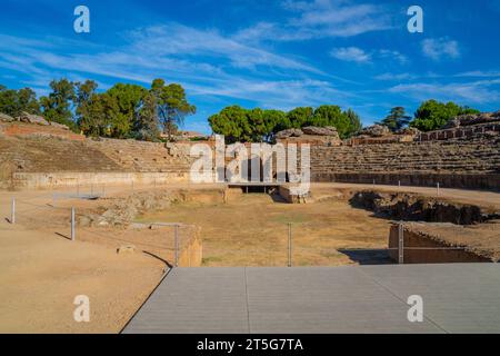Blick vom hölzernen Fußweg auf die Arena des römischen Amphitheaters von Mérida, beleuchtet durch das Licht der Morgendämmerung, die Schatten auf seinen Ständen mit dem erzeugt Stockfoto