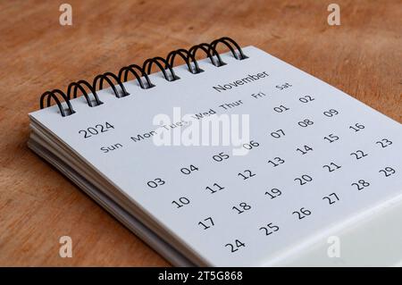November 2024 weißer Tischkalender auf hölzernem Hintergrund. Kalenderkonzept Stockfoto