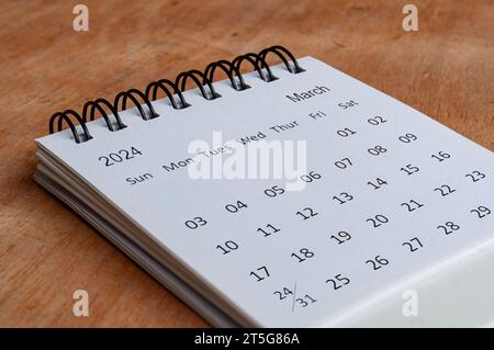 März 2024 weißer Tischkalender auf hölzernem Hintergrund. Kalenderkonzept Stockfoto