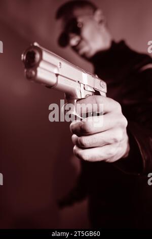 Schwarze Lederjacke Mörder Detective Spion Mörder Attentäter mit Gewehrporträt Foto. Stockfoto